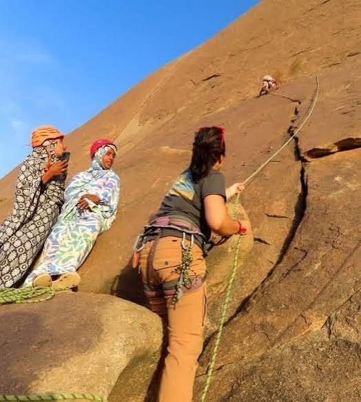 Travellers climbing the granite slopes of Ben Amira in the Mauritanian Sahara