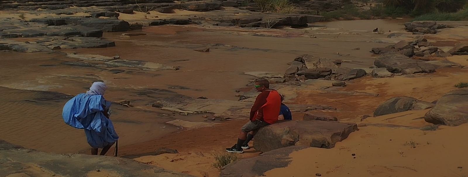 Travellers and a local guide resting on the rocks near Terjit